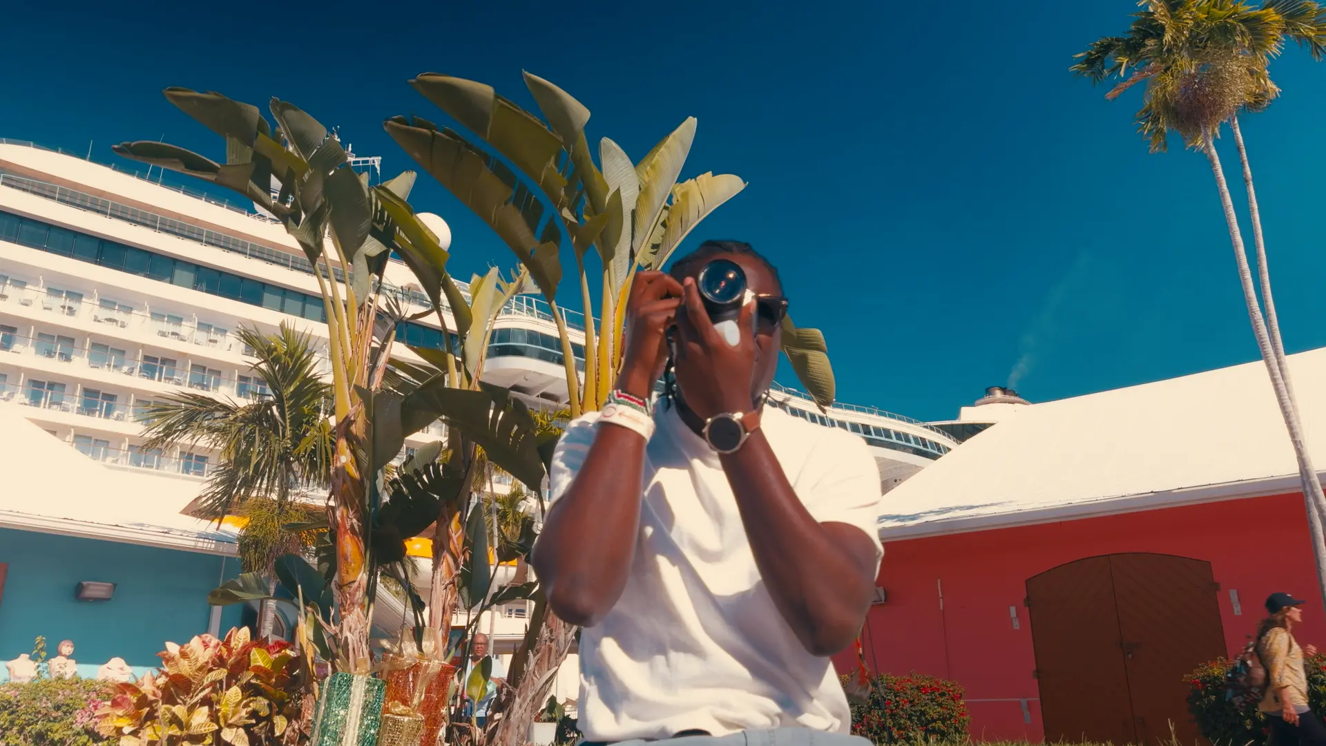 Filmmaker using a camera beside a ship, film-emulation grade